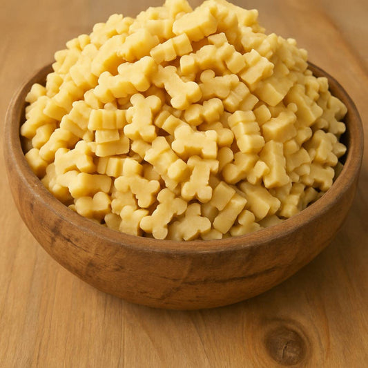 Wooden bowl filled with cheesy dog bone treats  on a wooden surface